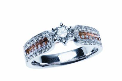 A diamond ring, the central modern brilliant cut diamond claw set above two tone diamond set shoulders. 18ct yellow and rose gold. Weight 6.06 grams.
