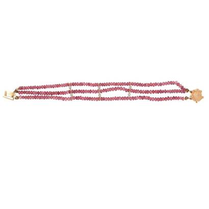 A pink tourmaline bracelet, of triple strand design with diamond set spacers and hung with a gold frog clasp. 14ct yellow gold. Weight 20.47 grams. &nbsp;Length 18.5cm.