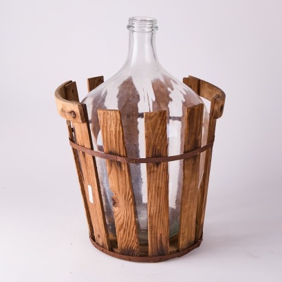 An Antique Carboy Bottle With Crate