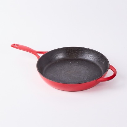 A Cast Iron and Red Enamel Skillet