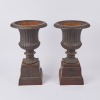 A Pair Of Cast Iron Urns With A Base